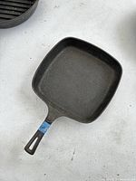 Top view of the square cast iron skillet showing the cooking surface and handle with numerical sticker