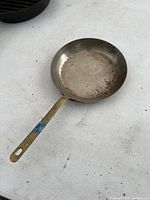 Copper sauce pan showing the interior, worn with scratches and tarnish