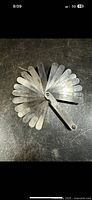 Fan of metal feeler gauge blades showing size markings and general condition