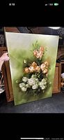 Large floral oil painting on canvas with peach and white flowers and green background.