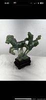Front view of vintage Chinese carved jade horses figurine showing two horses in dynamic pose on a wooden base, visible green and white color variations in jade.