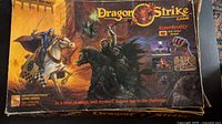 Photo of the Dragon Strike board game box showing damage and fantasy cover artwork