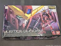 Boxed Bandai Real Grade Justice Gundam model kit with front box art showing the suit and logo.