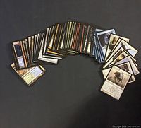Photo showing a fanned-out array of MTG cards showing backs and some fronts with various card colors and art.