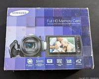 Samsung Full HD Memory Cam box showing the camcorder with Schneider Kreuznach lens, 20x optical zoom, BSI CMOS sensor, 4MP images, Intel Studio, USB charging