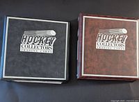 Two large binders with Hockey Collectors Trading Cards logos; one blue and one red binder shown closed