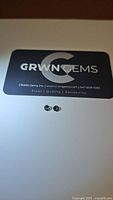 Pair of natural multicolored sapphires with CRWN Gems branding card background.