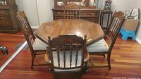 View of dining table and six chairs arranged, showing overall style and condition