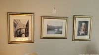 Three framed photographs hung on a wall showing various Italian architectural views including arched bridges and stone structures.