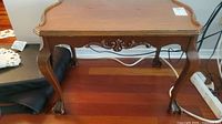 Front view of vintage Gibbard wooden side table showing carved decorative apron and elegant curved legs, surface visible wear.