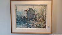 Photo of framed Kierstead enhanced print showing a rustic watermill beside a waterway with trees and foliage. Signed lower left.
