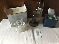 Lot items arranged on white cloth: clear crystal elephant figurine with box, brown glass candle holder, blue box with decorative friendship ball inside.