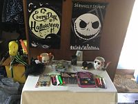 Full view of Halloween themed decor and accessories on a table with wall flags behind