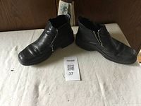 Pair of black Josef Seibel leather boots on white cloth background showing condition and size 38 indication.