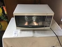 Front view of RCA microwave oven showing closed door and keypad control panel on right side.