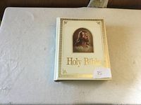 Front cover of the Holy Bible white hardcover featuring image of Jesus and gold text.