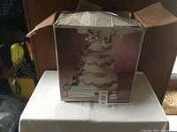 Box containing a picture of a multi-tier wedding cake on the cake stand