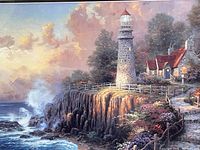 Close-up of the print showing lighthouse, cottage, rocky coast, ocean waves, and vibrant sky with clouds.