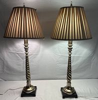 Pair of matching tall table lamps with pleated shades on a table against white backdrop