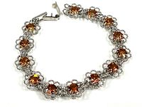 Full view of the sterling silver bracelet showing amber crystals and floral links.