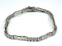 Full view of the silver bracelet laid flat showing clear crystals and engraved words 'LOVE' and 'HOPE'.