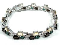 Full view of sterling silver bracelet showcasing colored crystals and chain links.