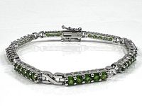Full view of the sterling silver bracelet with green crystals laid flat, showcasing the full length and clasp.