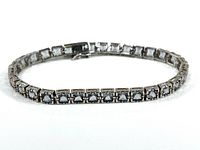 Full view of the sterling silver bracelet laid flat, showing square lavender crystals in individual settings.