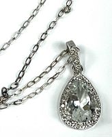 Close-up of the teardrop clear crystal pendant surrounded by smaller crystals on a sterling silver chain.
