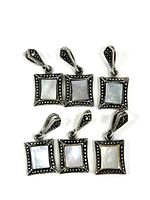 Six small square sterling silver pendants each with iridescent inlay and detailed silver bead work on frame and bail shown with front facing.