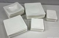 Top view of all dinnerware groupings arranged by type in neat stacks showing their square shapes and sizes.