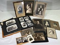 Wide view showing various vintage cabinet cards, a wooden photo album open to several pages with snapshots, and loose photographs.