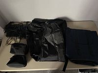 All bags arranged on table showing guitar bag, computer bag, two makeup bags, and handbag