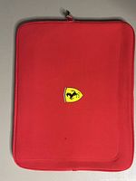 Front side of the red laptop case showing Ferrari shield logo