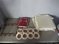 All six storage items laid flat on table: metal hooks, hanging tie holder, fabric organizer, and soft storage bags