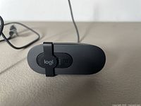 Close-up of the black Logitech webcam from front top view showing the lens and clip mount with logi branding.