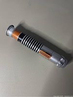 Close-up of lightsaber handle showing design and minor surface wear.