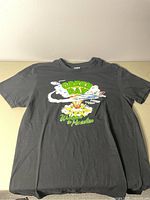 Full frontal image of the black Green Day T-shirt laid flat, showing the graphics and overall condition.