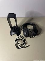 Razer headphones wired with cushioned ear cups placed next to black USB stand with wire guide and USB ports