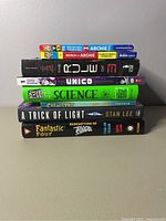 Books stacked sideways showing spines and titles for identification