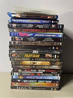 Stacked DVDs showing spines with various titles including Transformers, Predators, Lord of the Rings trilogy, Fight Club and others