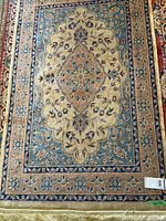 Full view of the oriental floral rug showing overall pattern and colors including blue, beige, and peach.