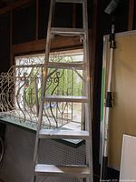 Close-up side view of aluminum step ladder steps and frame.