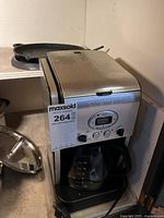 Front and side view of the stainless steel Cuisinart coffee maker showing the digital control panel and glass carafe on the base.