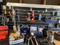 Overview of the workbench showing assorted tools including clamp, wrenches, lantern, drill bits, and toolboxes