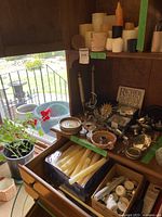 Photo showing additional candles on a shelf above a drawer including candles stacked together and more small decorative items.