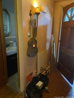 View showing acoustic guitar and trumpet lamps mounted on a wall near a doorway, music books placed below, and guitar hanger mounted nearby.
