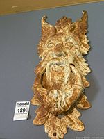 Full front view of wall-mounted metal Old Man Winter face sculpture showing overall shape and rust patina