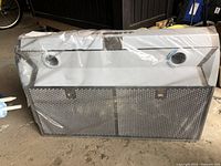 Front view of the range hood showing metal mesh filter and ventilation holes.