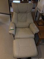Front view of cream leather recliner and matching ottoman
